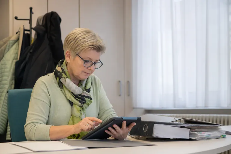 Pflegedienstleitung plant Fristen für Pflegeunterlagen in einem digitalen Kalender.